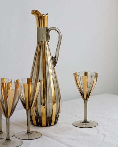 Vintage gold and silver pitcher with matching glasses on a white surface curated by Parliament Interiors in Vancouver, BC.